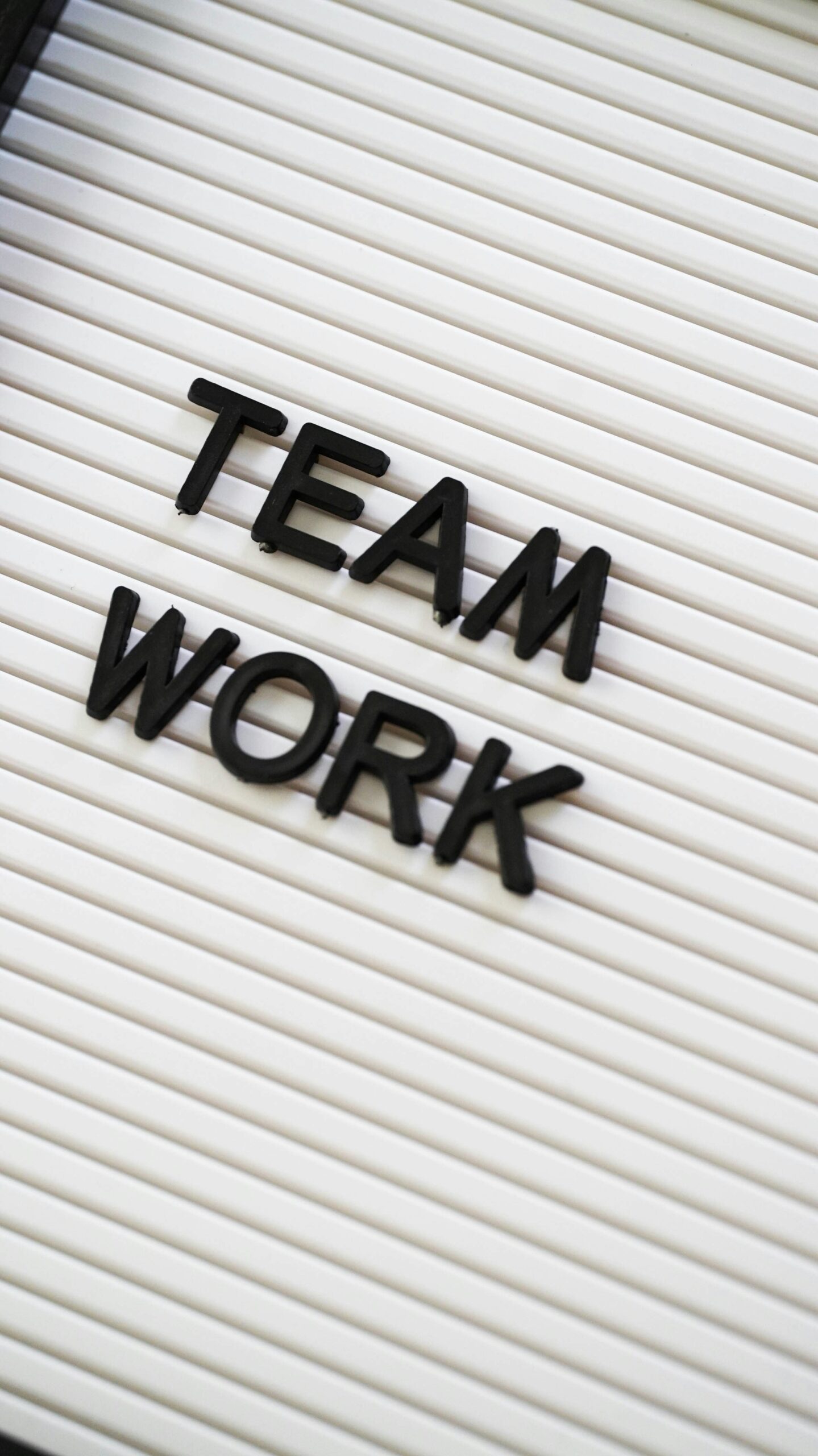 A white sign with black text that reads "Team work"